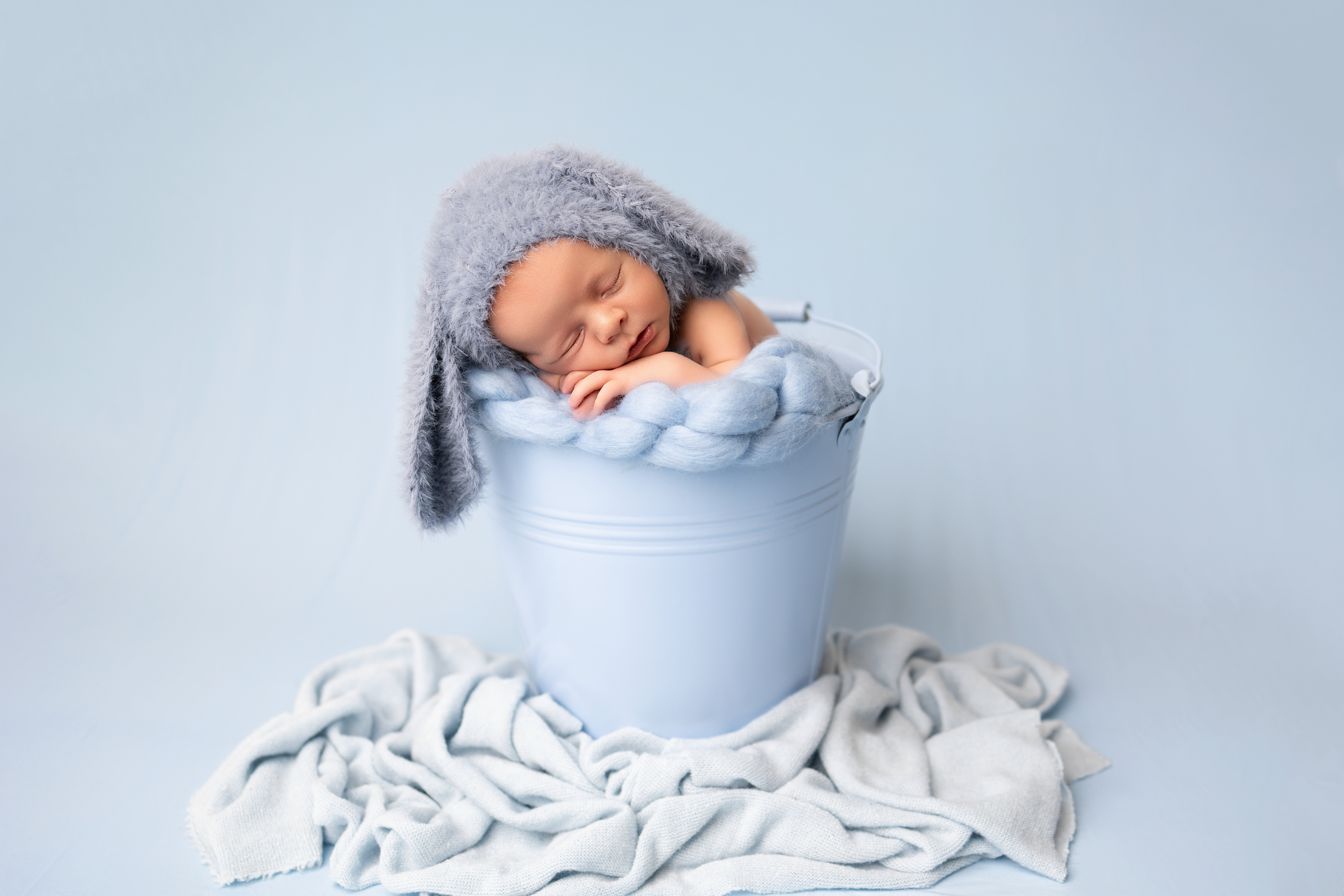 sleeping in bucket with teddy wearing bunny ear hat